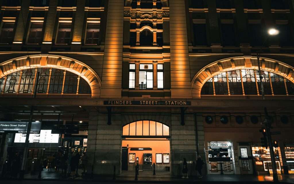 The lit facade of Flinders Street Station at night